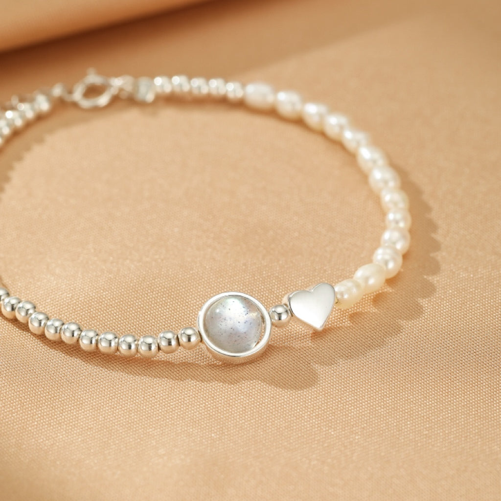 Bracelet en argent 925 avec une pierre de lune ronde, un cœur nacré et de petites perles.