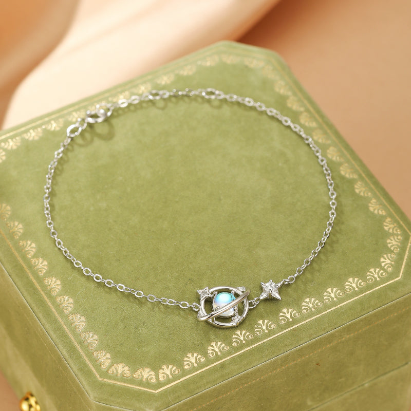 Bracelet en argent 925 avec un pendentif planète orné d'une pierre de lune et d'une étoile scintillante, style galactique.