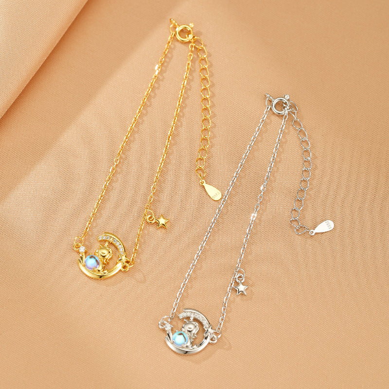 Bracelet Harmonie Lunaire en argent 925, avec un pendentif en forme de croissant de lune orné d'une pierre de lune bleue et d'une petite étoile scintillante.