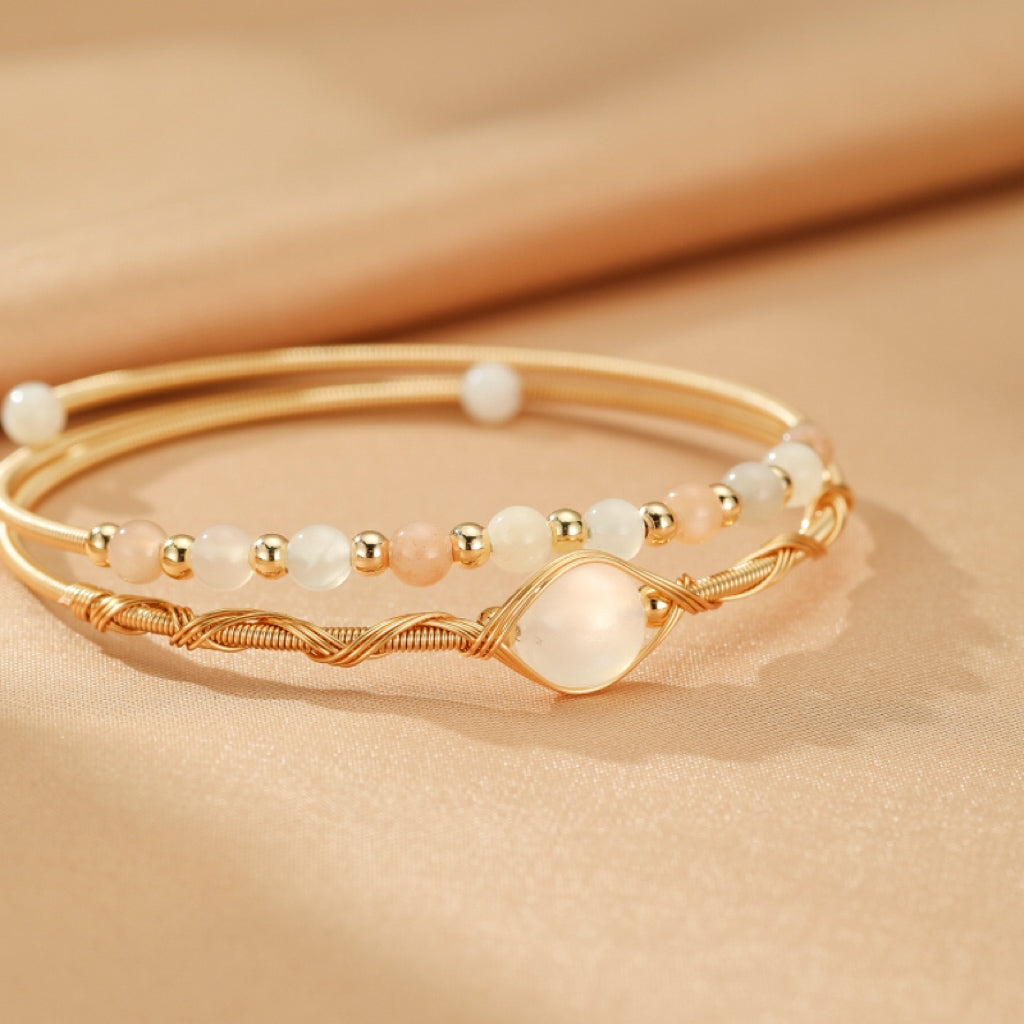 Ensemble de deux bracelets fins en plaqué or 14K ornés de petites perles nacrées et roses, avec un élément central en forme de goutte en pierre de lune.
