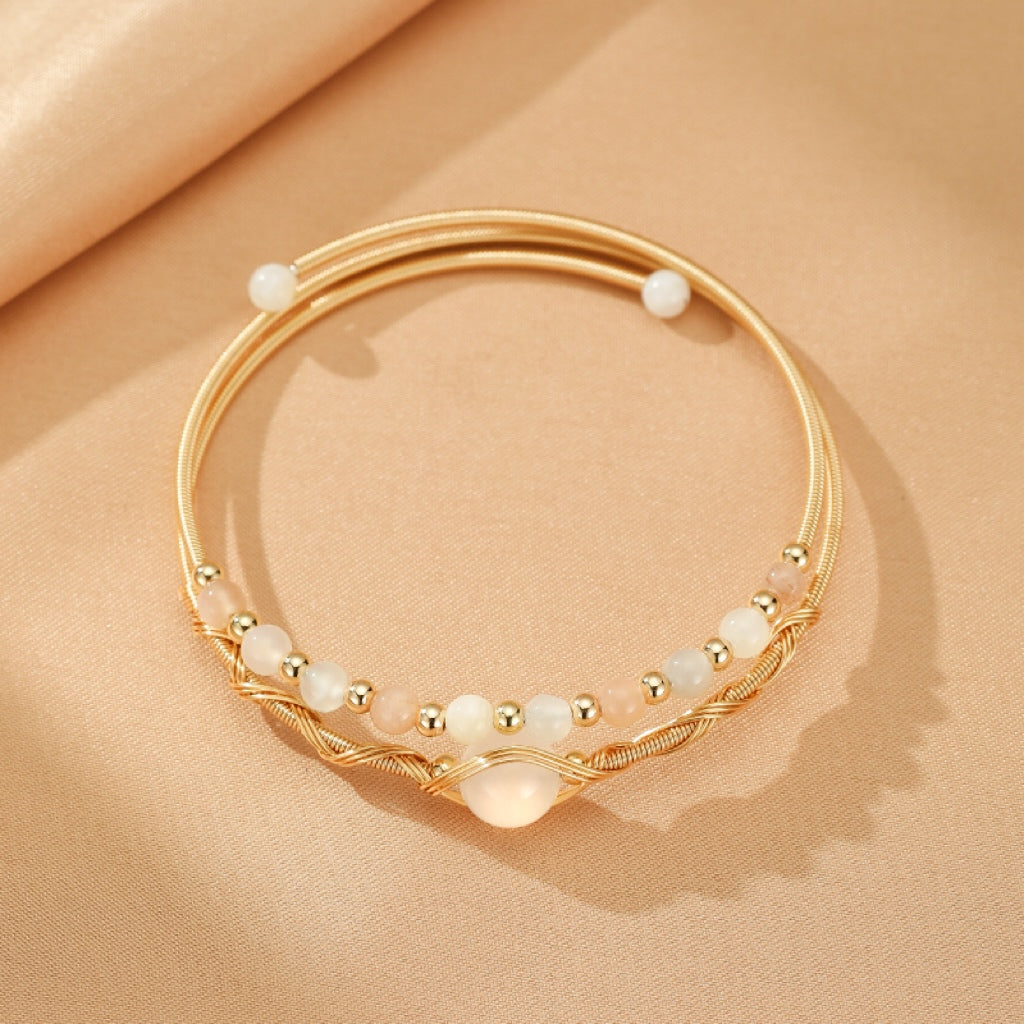 Bracelet jonc fin en plaqué or 14K, orné de perles de pierre de lune et de petites perles dorées, avec une pierre centrale irisée centrale.