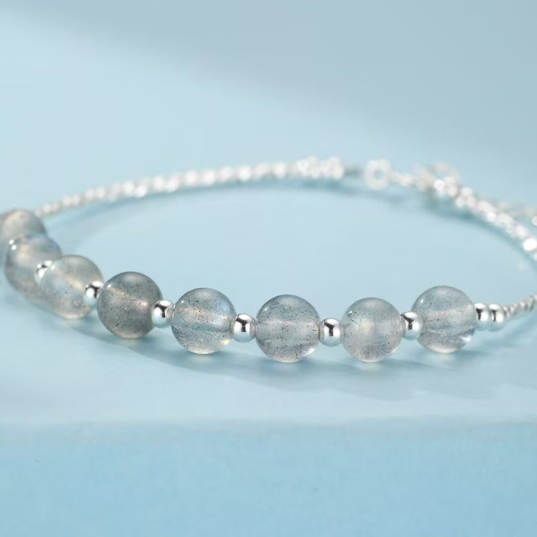 Bracelet en argent avec des perles rondes de pierre de lune bleutées et des petites perles d'argent.