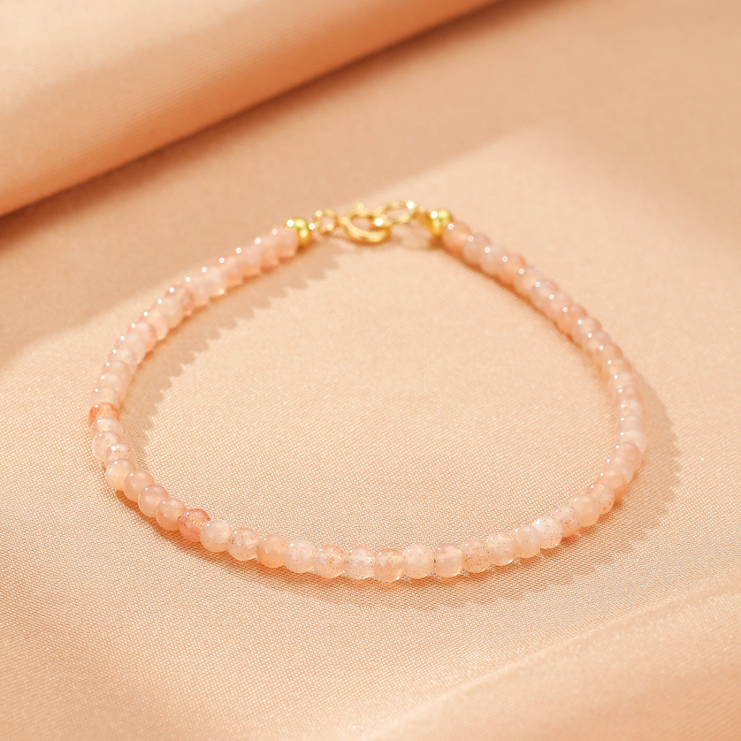 Bracelet fin en pierres de soleil facetées roses avec fermoir doré.