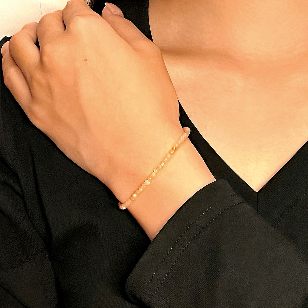 Bracelet fin en pierres de soleil sur le poignet d'une femme, bijou Aura Fine.