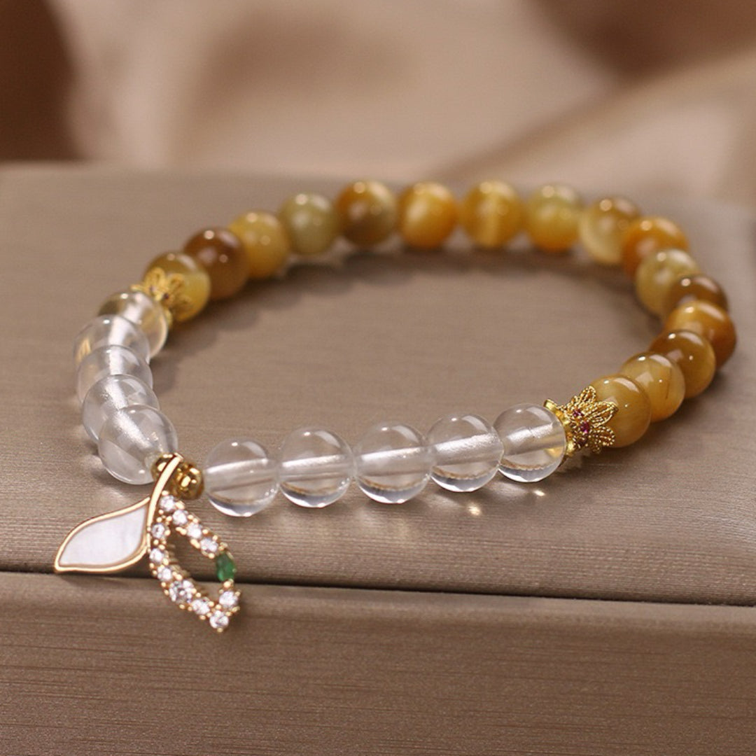 Bracelet fait de perles de quartz clair et d'œil de tigre, orné d'un pendentif feuille nacrée et de zircons cubiques.