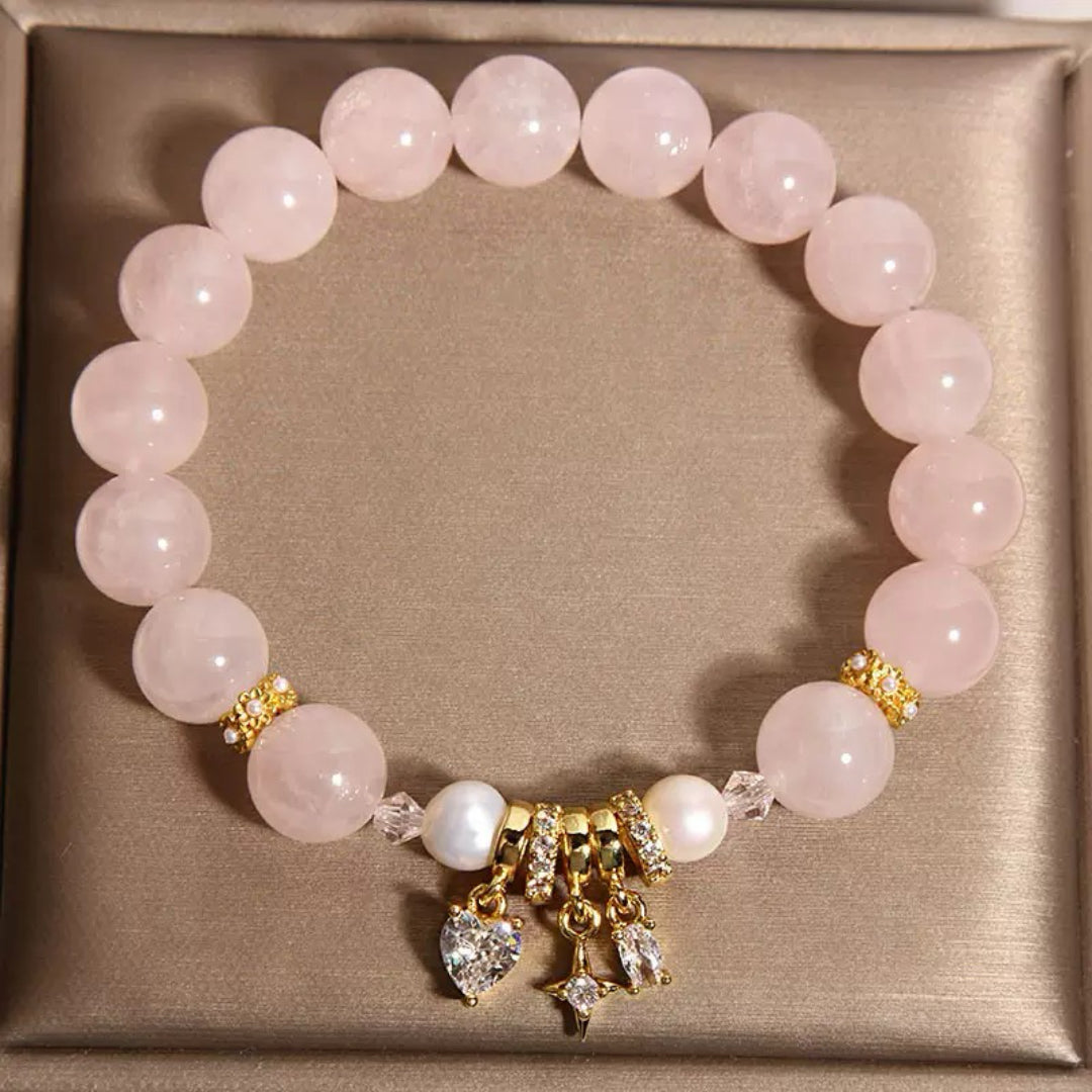 Bracelet en quartz rose avec perles et breloques en forme de cœur et d'étoile, rehaussé de zircons cubiques et de détails dorés.