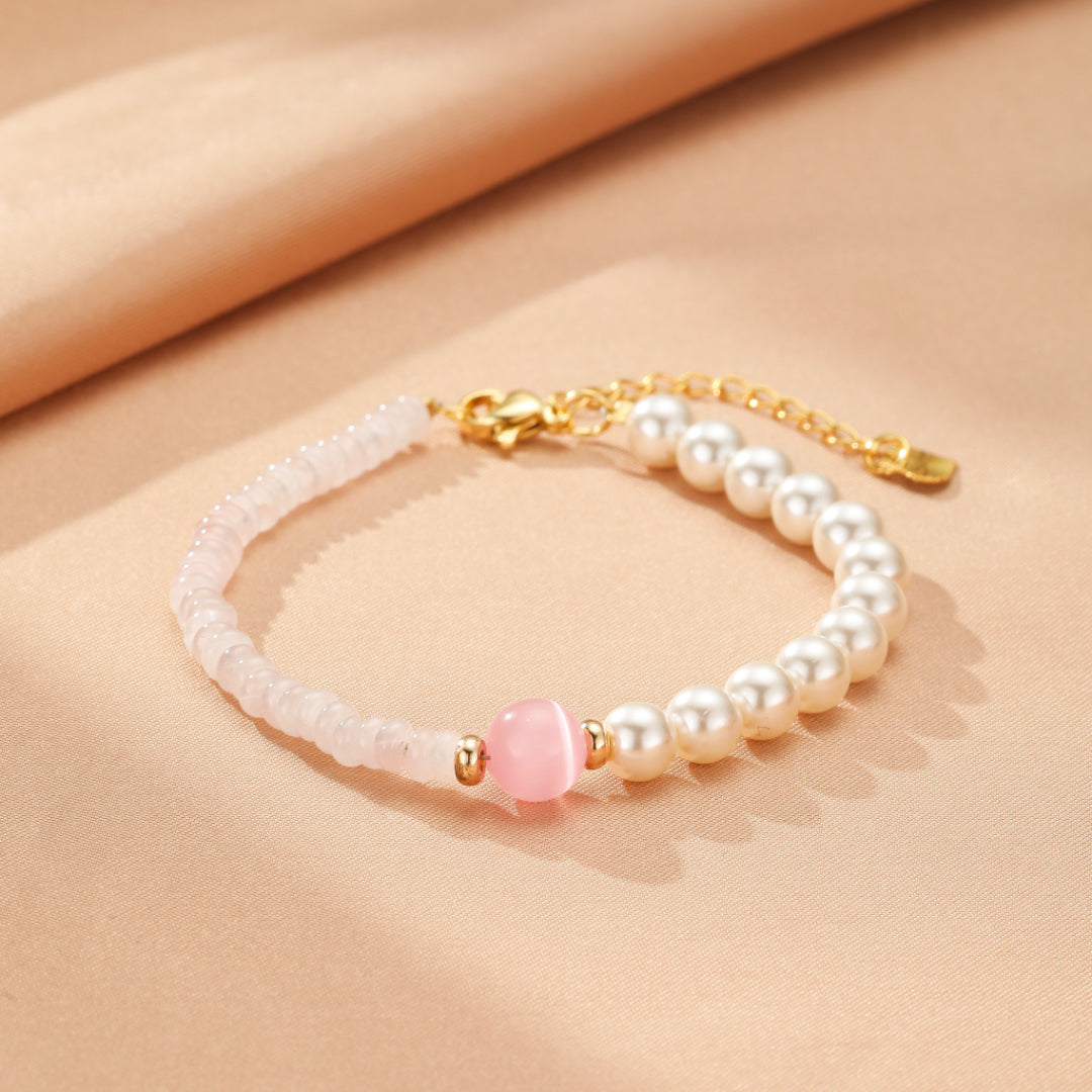 Bracelet délicat en quartz rose et perles nacrées avec une pierre centrale rose, fermoir doré et chaîne d'ajustement.