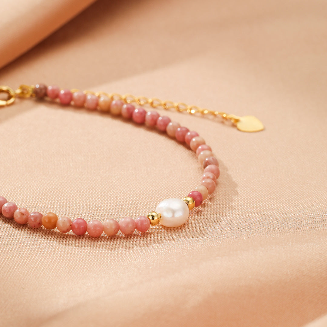 Bracelet délicat en rhodonite rose et perles d'eau douce avec fermoir plaqué or et breloque en forme de cœur.
