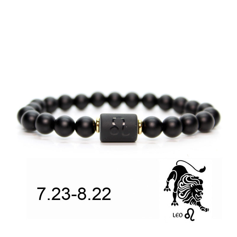 Bracelet en onyx noir avec un cylindre central gravé du symbole du Lion et de ses dates (23.07 - 22.08), rehaussé de perles dorées. Le symbole astrologique du Lion et son lion stylisé sont également visibles.