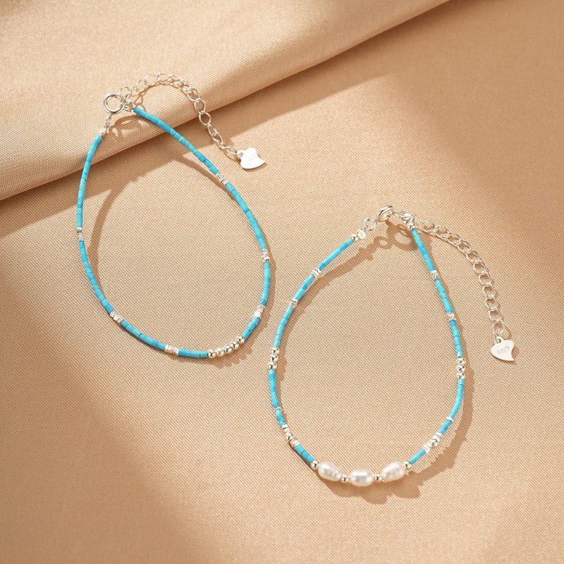 Deux bracelets fins en argent, l'un orné de perles de turquoise et de petites perles d'argent, l'autre de perles de turquoise, de petites perles d'argent et de trois perles de culture blanches.