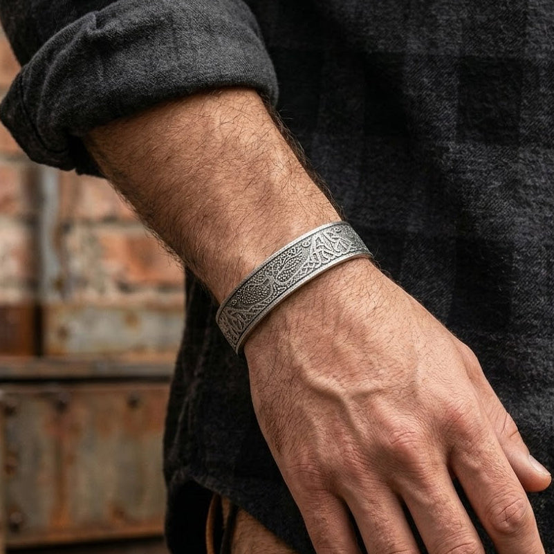 Bracelet viking Arbre de Vie en argent vieilli, avec des motifs complexes entrelacés représentant l'arbre de vie, porté au poignet d'un homme.