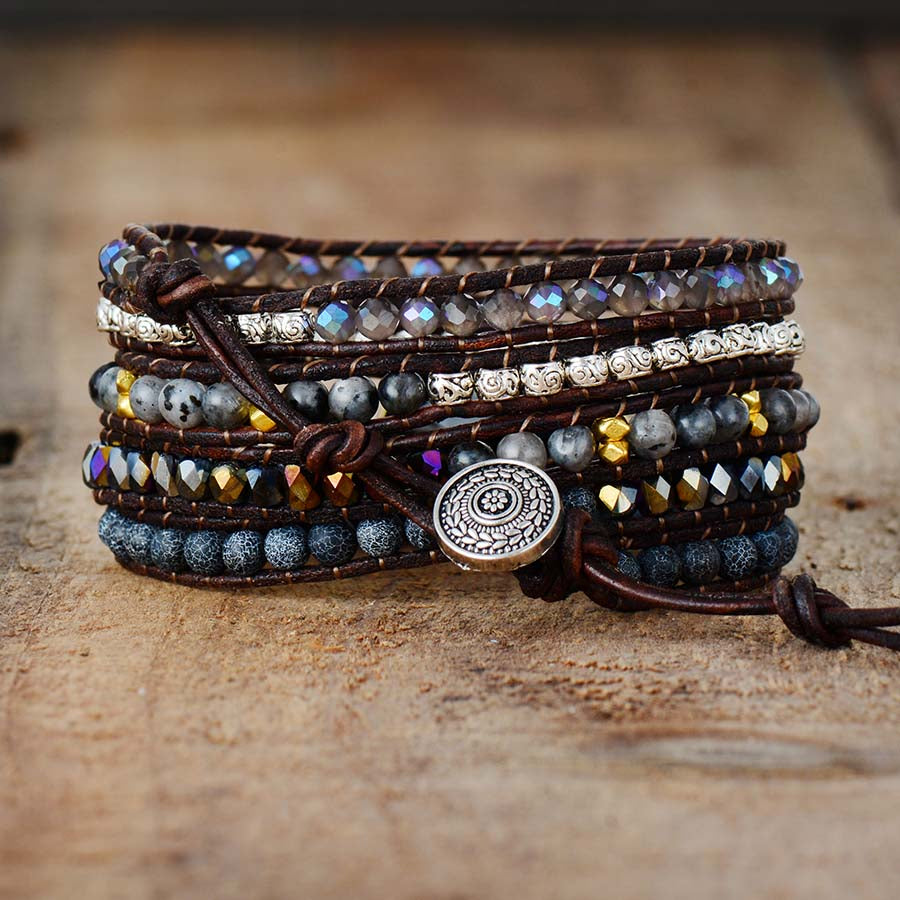 Bracelet jonc enveloppant en cuir marron avec des perles en onyx, des perles grises et des accents métalliques, fermé par un bouton décoratif.