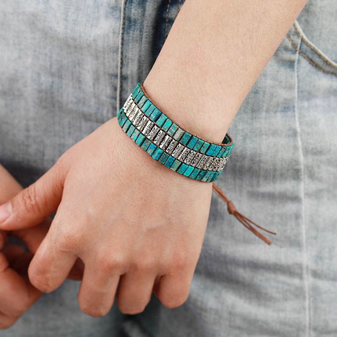 Bracelet jonc triple rangs en turquoise et argent vieilli, style ethnique, porté au poignet.