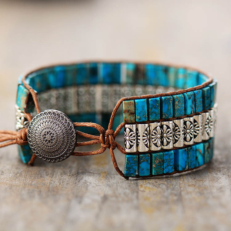 Bracelet jonc ethnique en pierre turquoise et perles argentées, fermé par un bouton décoré et un cordon en cuir marron