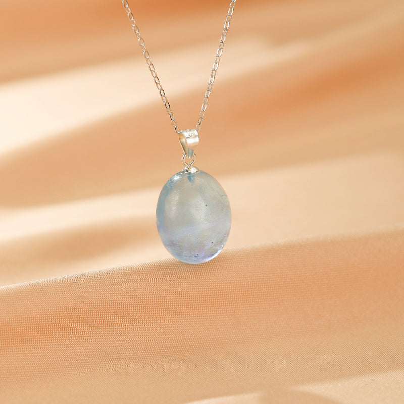 Collier en argent avec un pendentif ovale en aigue-marine bleu pâle, évoquant l'eau cristalline.