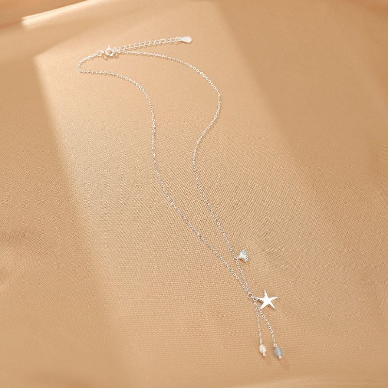 Collier Étoile des Mers en argent S925 avec une aigue-marine bleue et des perles blanches, orné d'un pendentif étoile et d'une chaîne fine.