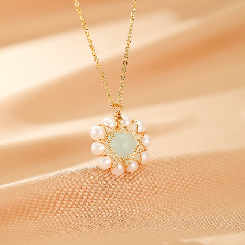 Collier en or fin avec un pendentif en forme d'étoile composé d'une aigue-marine centrale et de petites perles blanches.