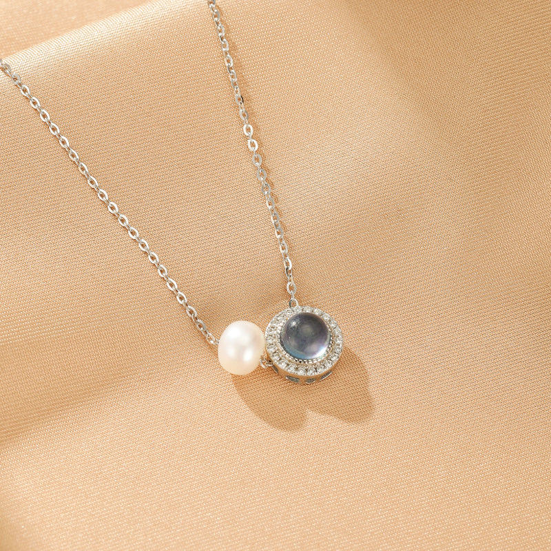 Collier en argent 925 avec une aigue-marine ronde sertie de zircons et une perle blanche.