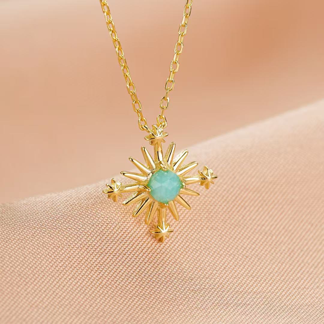 Collier en argent plaqué or avec une pierre d'amazonite centrale et un pendentif en forme de croix étoilée.