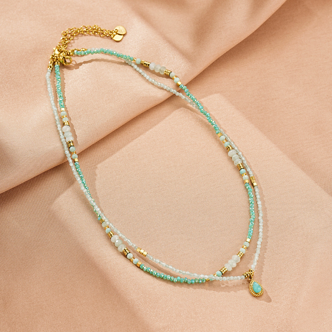 Collier double chaîne orné de perles d'amazonite turquoise et de petites perles blanches, avec un pendentif goutte d'amazonite turquoise.