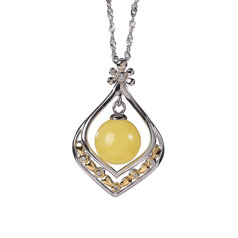 Collier Ambre Goutte de Soleil en argent avec une perle d'ambre jaune centrale et détails sertis de zircons sur une monture élégante en forme de goutte