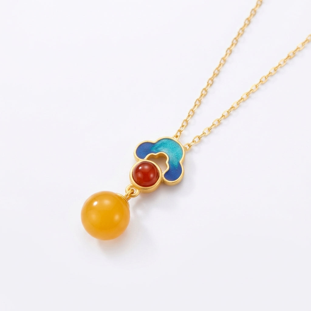 Collier Nuage Précieux en argent plaqué or avec pendentif perle d'ambre, pierre rouge et détails en émail bleu.