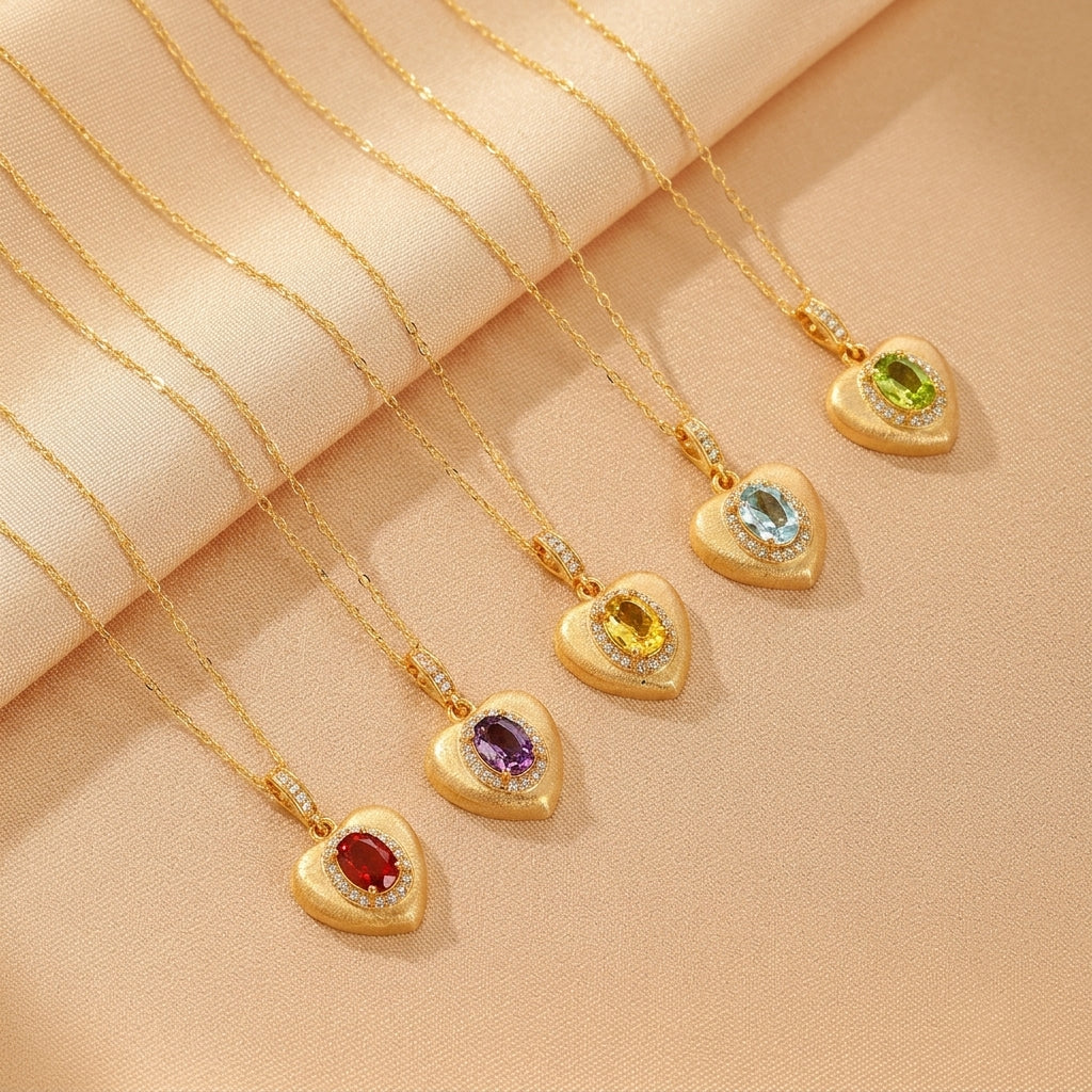 Cinq colliers en argent plaqué or avec pendentifs en forme de cœur ornés de différentes pierres précieuses : grenat, améthyste, citrine, topaze bleue et péridot, entourées de petits diamants.