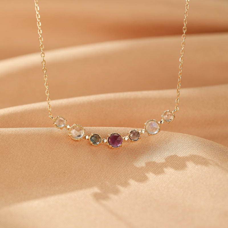 Collier "Enchanteur" en argent plaqué or, orné d'une rangée de pierres naturelles colorées : améthyste, labradorite, topaze, et autres gemmes.