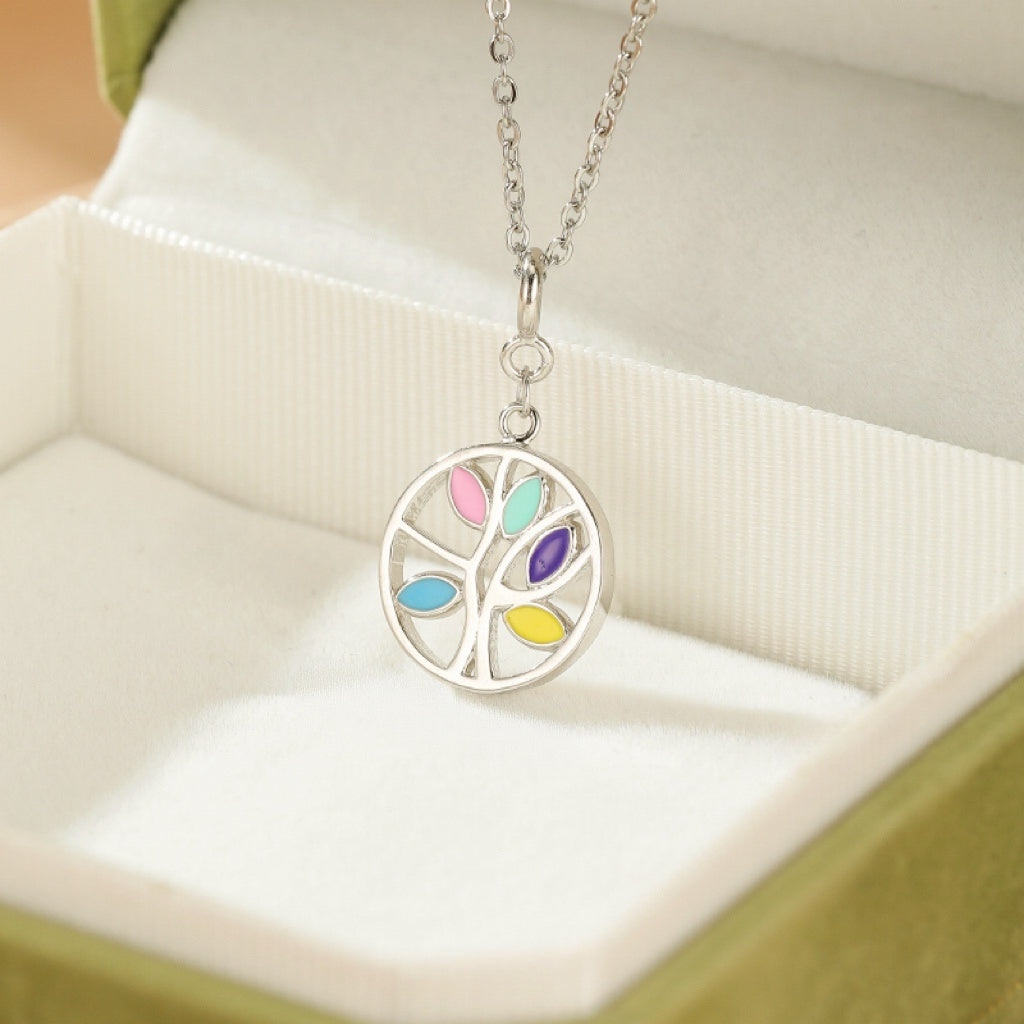 Collier Arbre de Vie en argent avec des feuilles colorées en rose, bleu clair, violet, bleu et jaune, présenté dans une boîte cadeau verte.