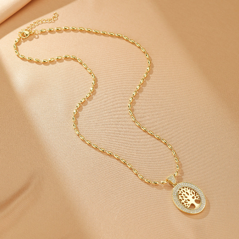Collier Arbre de Vie plaqué or avec pendentif ovale serti de zircons blancs et motif ajouré d'un arbre de vie.