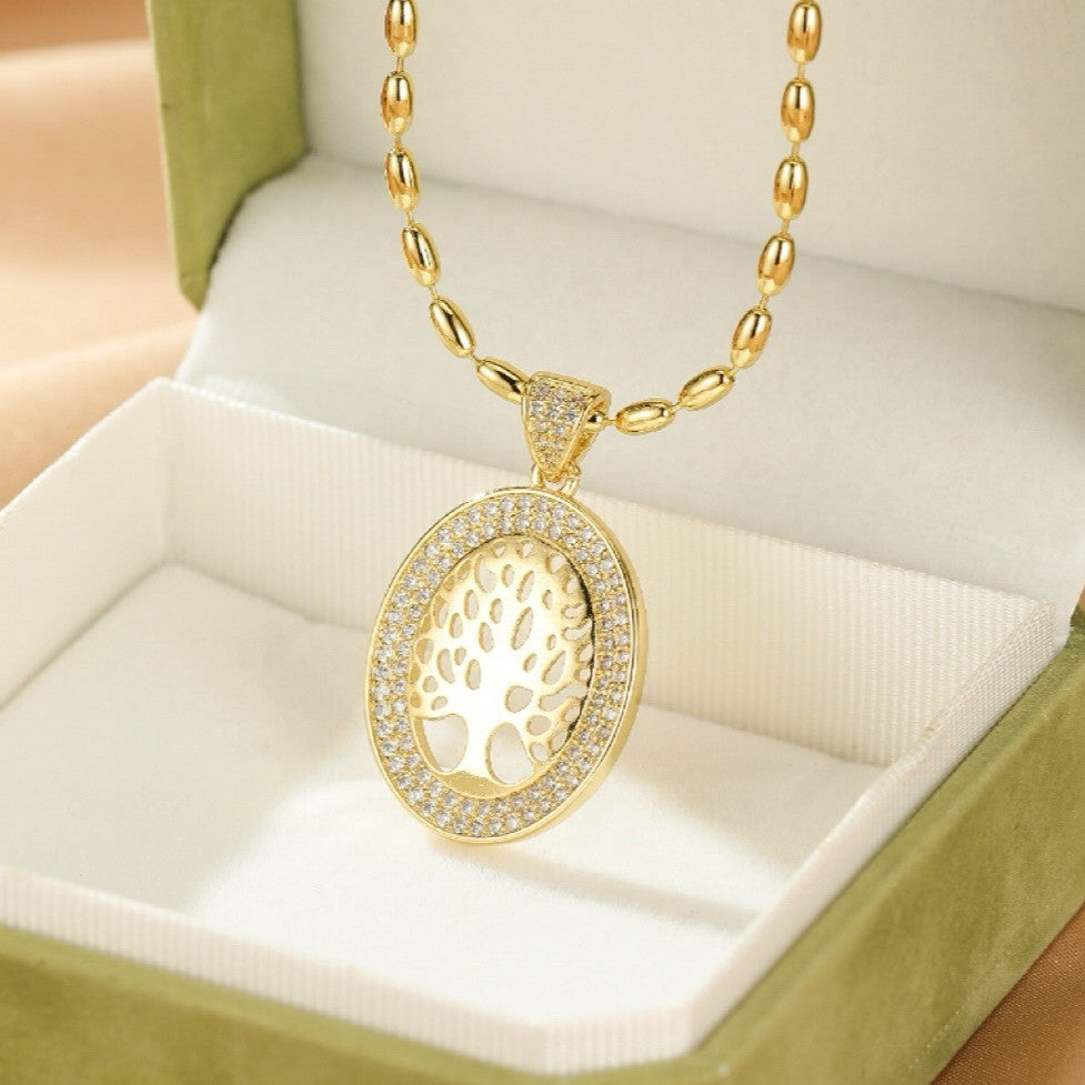 Collier Arbre de Vie en or jaune, pendentif ovale ajouré d'un arbre stylisé, entourage de zircons brillants.