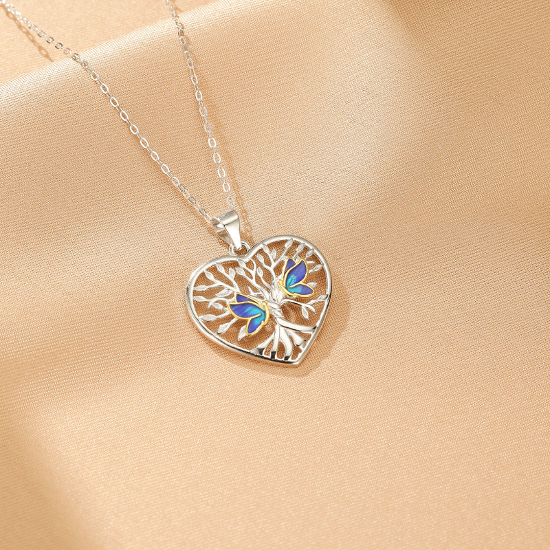 Collier Arbre de Vie en argent 925 avec un pendentif en forme de cœur orné de papillons bleus et de branches dorées.