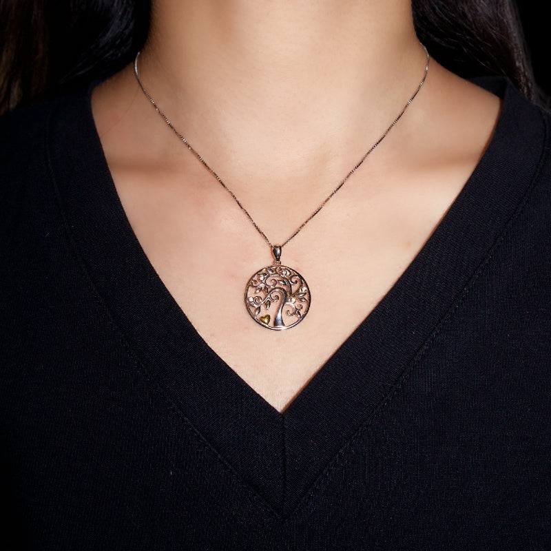 Collier Arbre de Vie en Argent 925 porté par une femme, avec un pendentif rond ajouré représentant un arbre stylisé avec des détails délicats.
