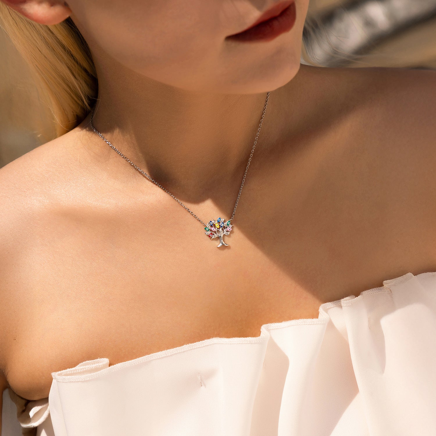 Collier Arbre de Vie en argent 925 avec un pendentif arbre de vie orné de pierres multicolores, porté par une femme.