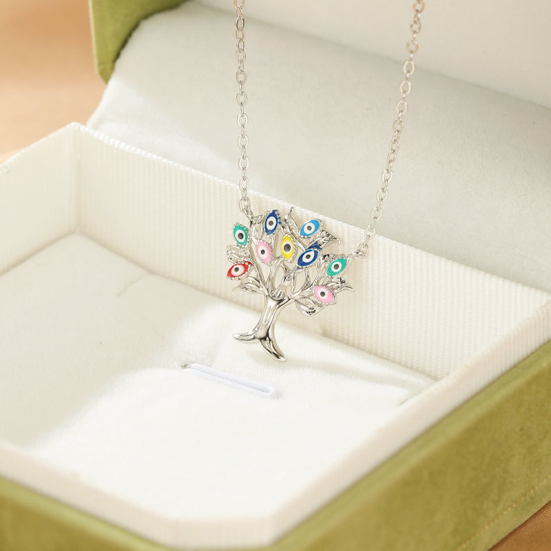 Collier Arbre de Vie en argent 925 avec des ornements colorés en forme de mauvais œil, présenté dans un écrin vert.