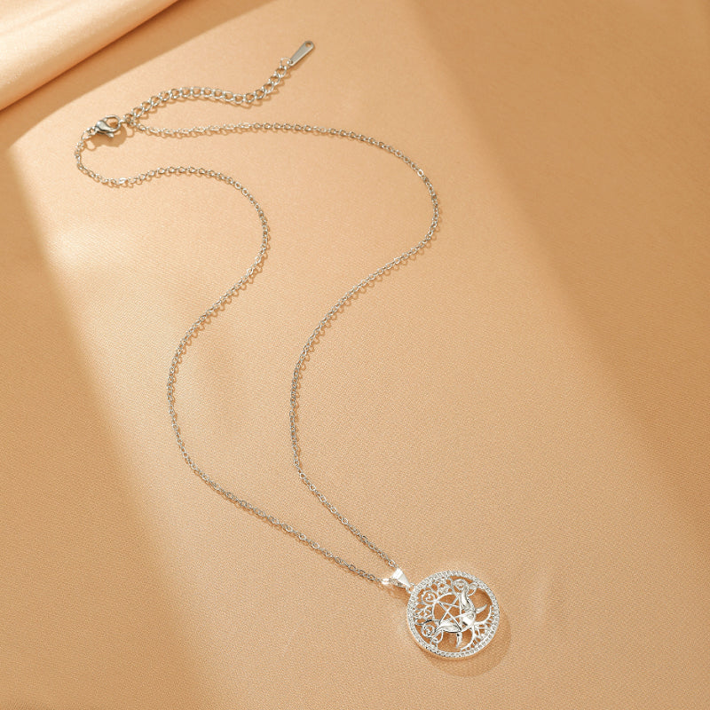 Collier Arbre de Vie en argent avec pendentif rond orné de cristaux et d'un motif d'arbre stylisé, sur fond beige.