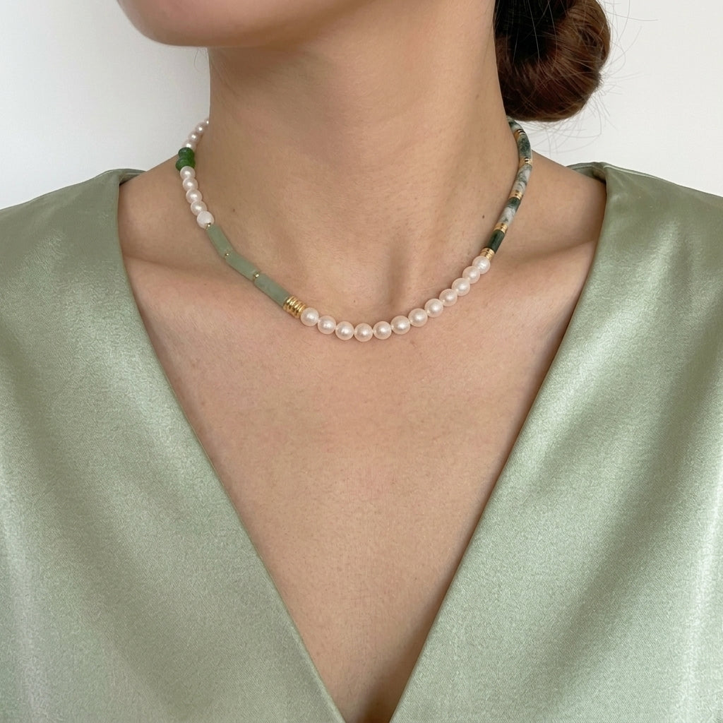 Collier Aventurine et Perle – Onde Apaisante, Argent Plaqué Or, orné de perles blanches et de pierres cylindriques vertes porté par une femme. 