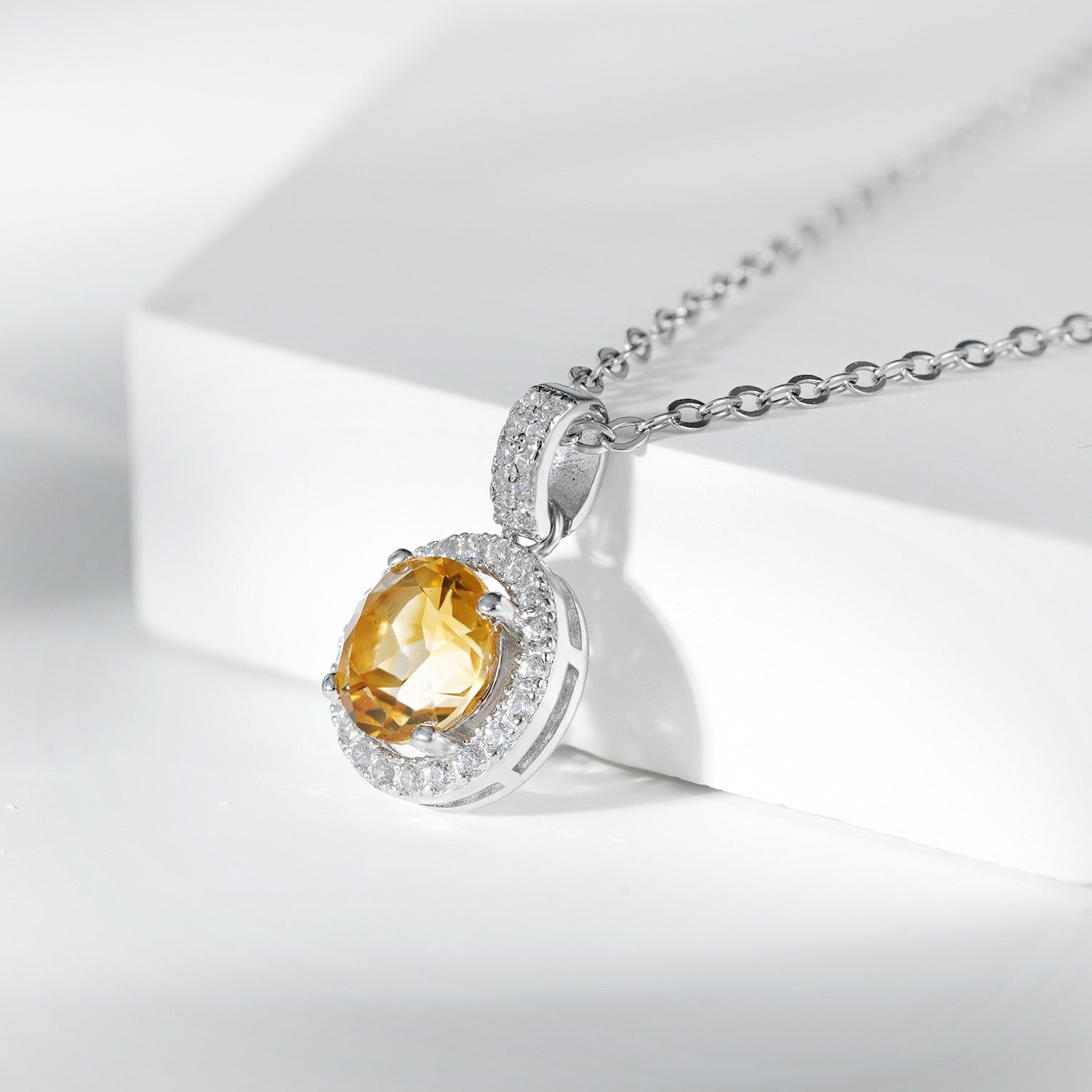 Collier en argent 925 avec pendentif citrine ovale entouré de zirconiums cubiques blancs et une chaîne fine.