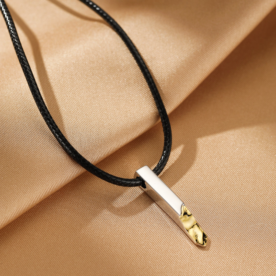 Collier pour couple, pendentif rectangulaire en argent avec détails dorés texturés, sur un cordon noir.