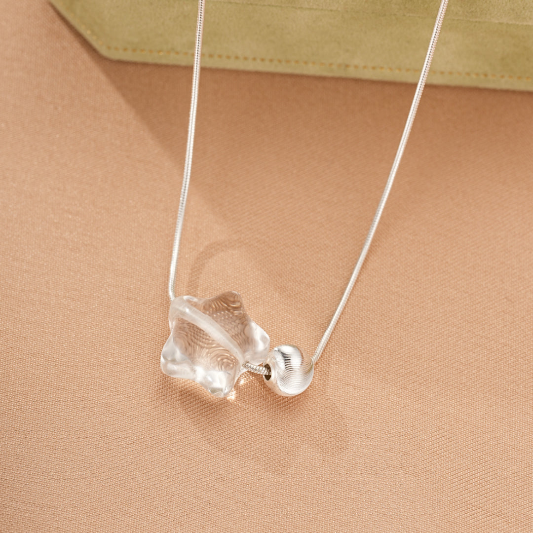Collier en argent avec un pendentif en forme d'étoile en cristal de roche et une perle argentée