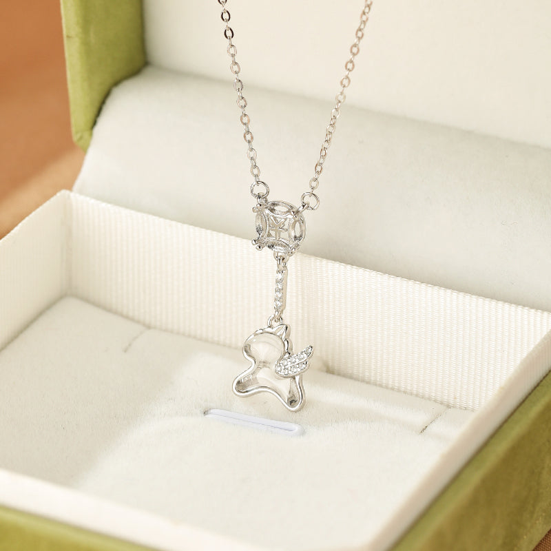 Collier en argent avec pendentif licorne ailée sertie de cristaux et une pierre carrée au centre.