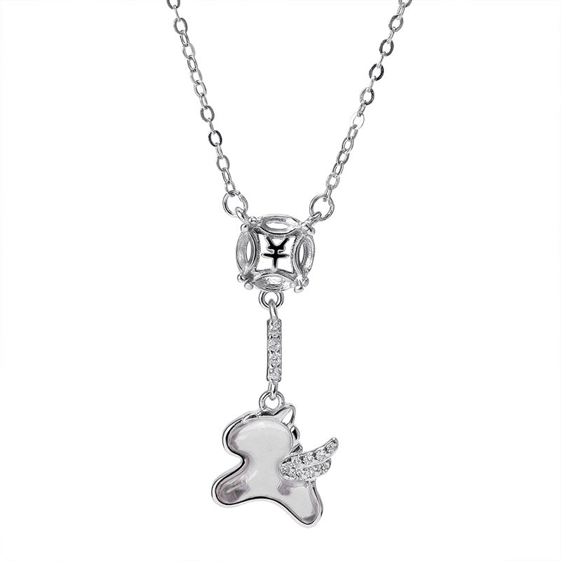 Collier en argent avec un pendentif représentant un petit animal ailé orné de strass, suspendu à une chaîne délicate avec un élément décoratif carré.