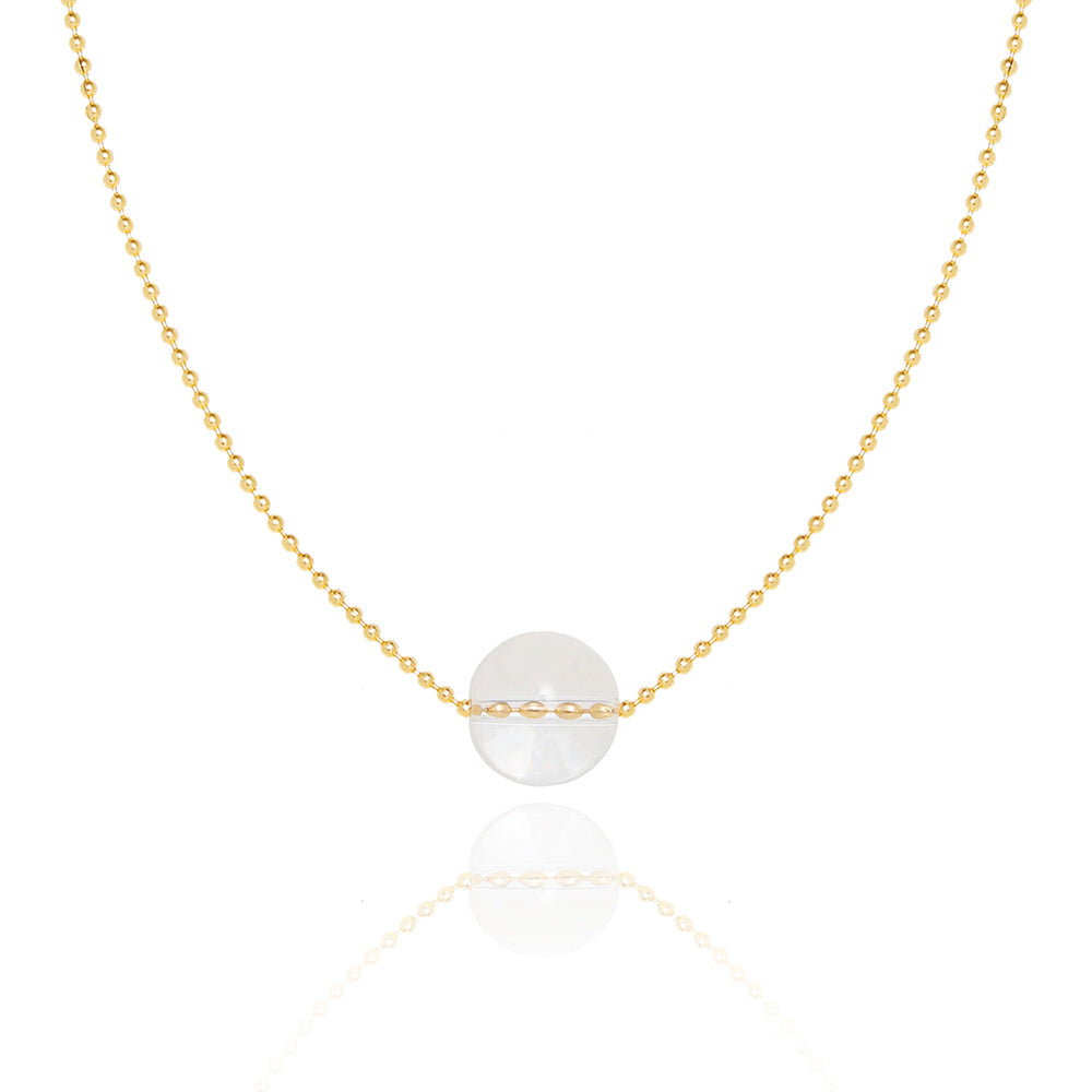 Collier en or jaune avec une perle ronde en cristal de roche transparent suspendue au centre, nom du produit Lumière Pure.
