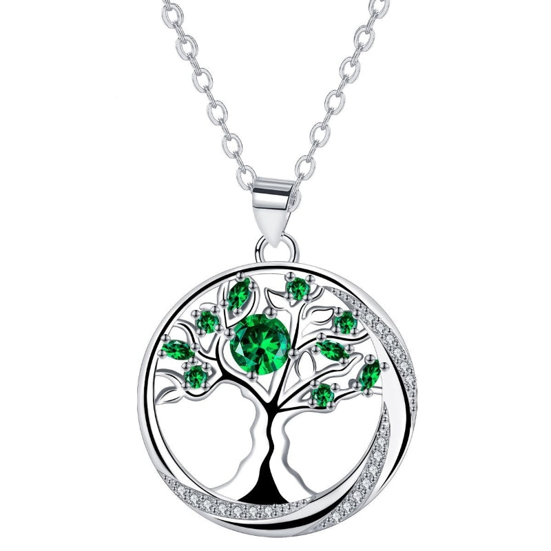 Collier "Arbre Éternel" en argent avec un grand pendentif circulaire représentant un arbre de vie orné de pierres émeraude et de cristaux blancs brillants.