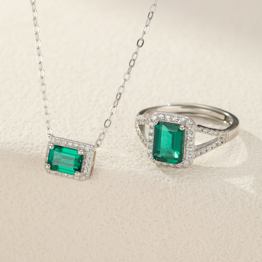 Ensemble de bijoux "Cœur de Forêt" comprenant un collier et une bague en argent 925 ornés d'émeraudes rectangulaires et de petits cristaux scintillants.