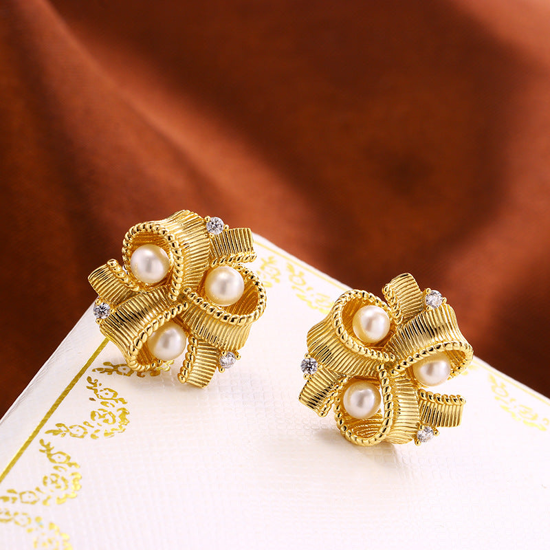 Paire de boucles d'oreilles plaqué or 18K à perles et détails scintillants, design nœud sophistiqué.