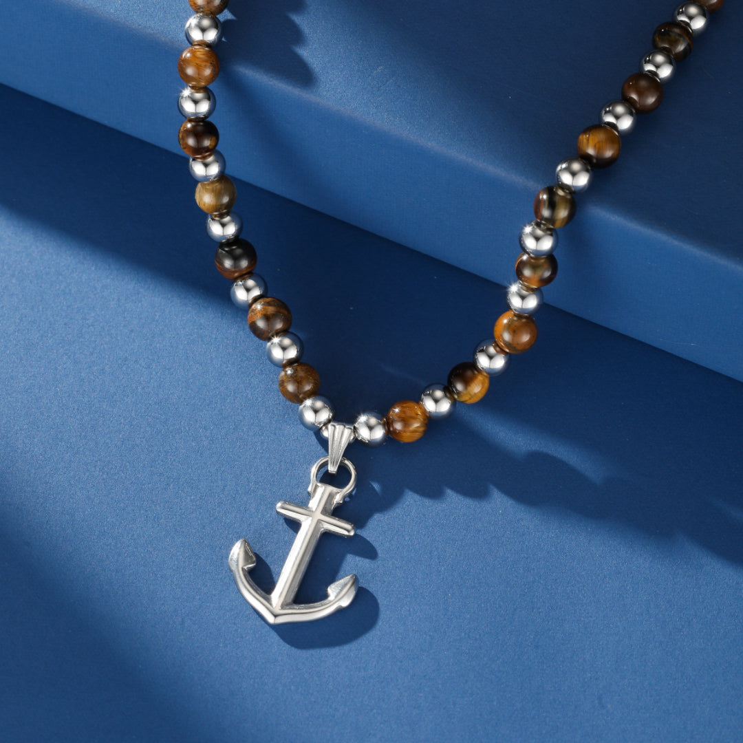Collier pour homme avec perles naturelles œil de tigre et un pendentif en forme d'ancre marine en argent.