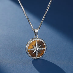 Collier Homme Œil de Tigre – Étoile du Destin, pendentif rond en œil de tigre avec une étoile de boussole gravée en argent et une bordure ornementale.