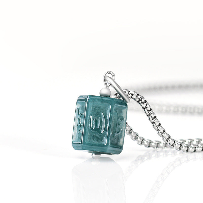 Collier pour homme Maître des Ombres avec pendentif cube en jadéite verte gravée et chaîne en argent sur fond blanc