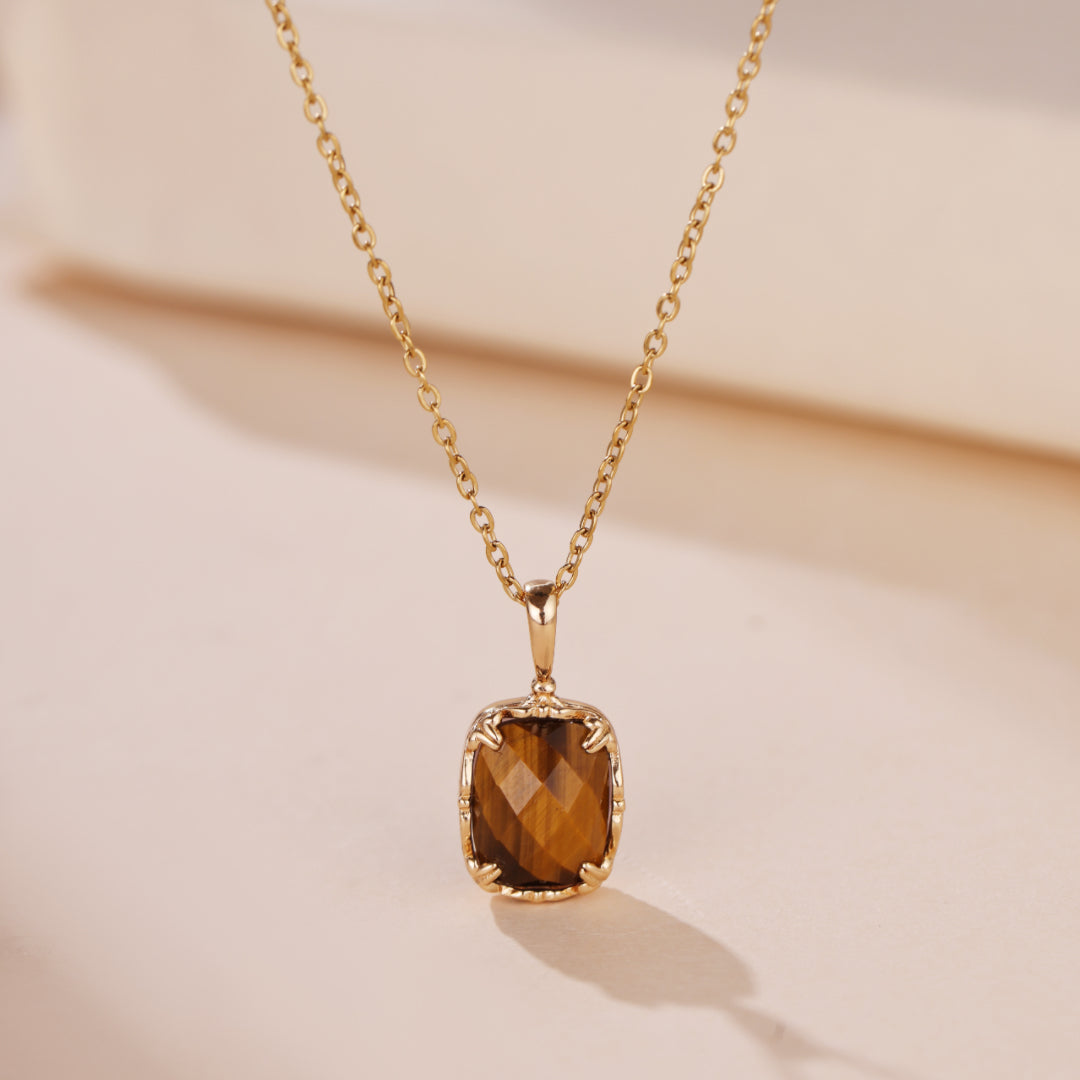 Collier en argent plaqué or avec un pendentif œil de tigre facetté de forme carrée, sur une chaîne délicate.